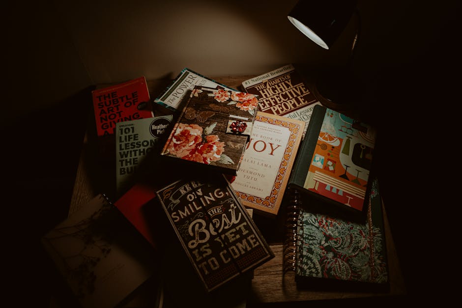 A collection of books illuminated under a lamp, creating a warm and inviting reading space.