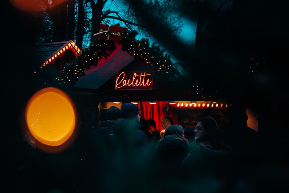 Experience the warm Christmas ambiance at Berlin's charming raclette market stall, perfect for winter festivities.