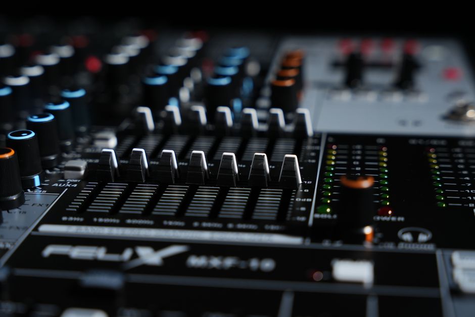 Close-up view of a professional audio mixing console with faders and dials.